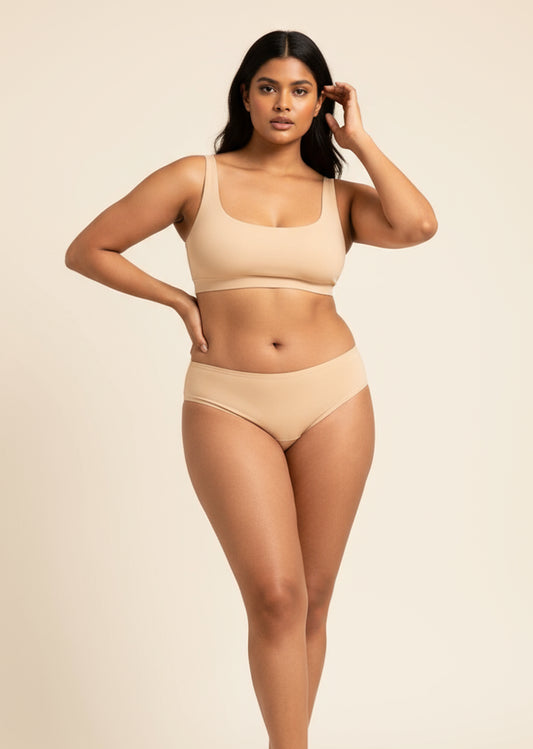 Woman wearing beige bra and underwear on a beige background