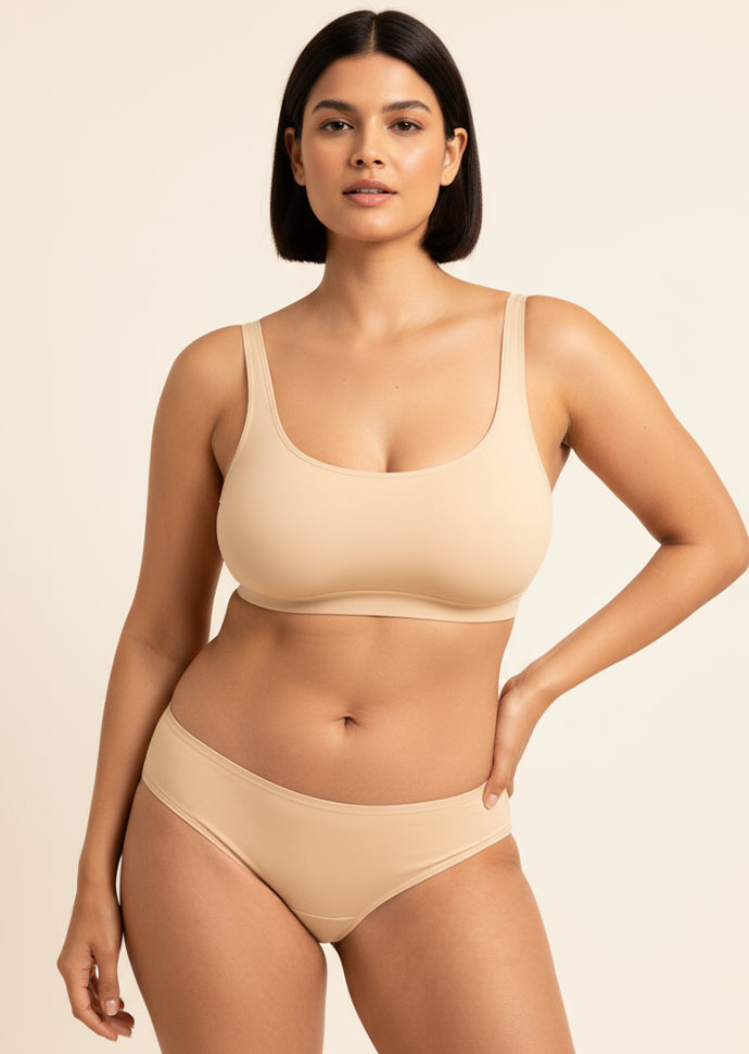 Woman wearing a beige bra and panties on a beige background