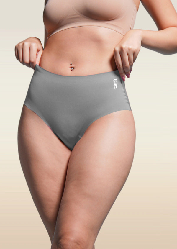 Person wearing gray underwear with a beige background